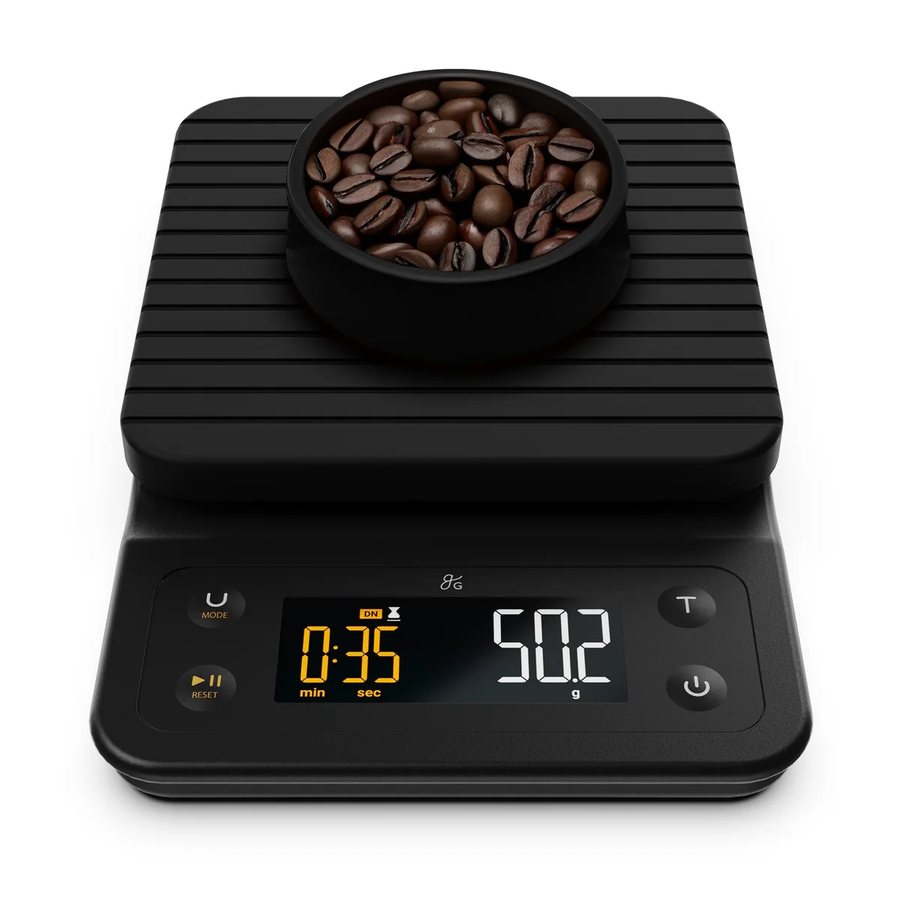 Greater Goods Premium Coffee Scale, black, with a cup of beans and a lit display